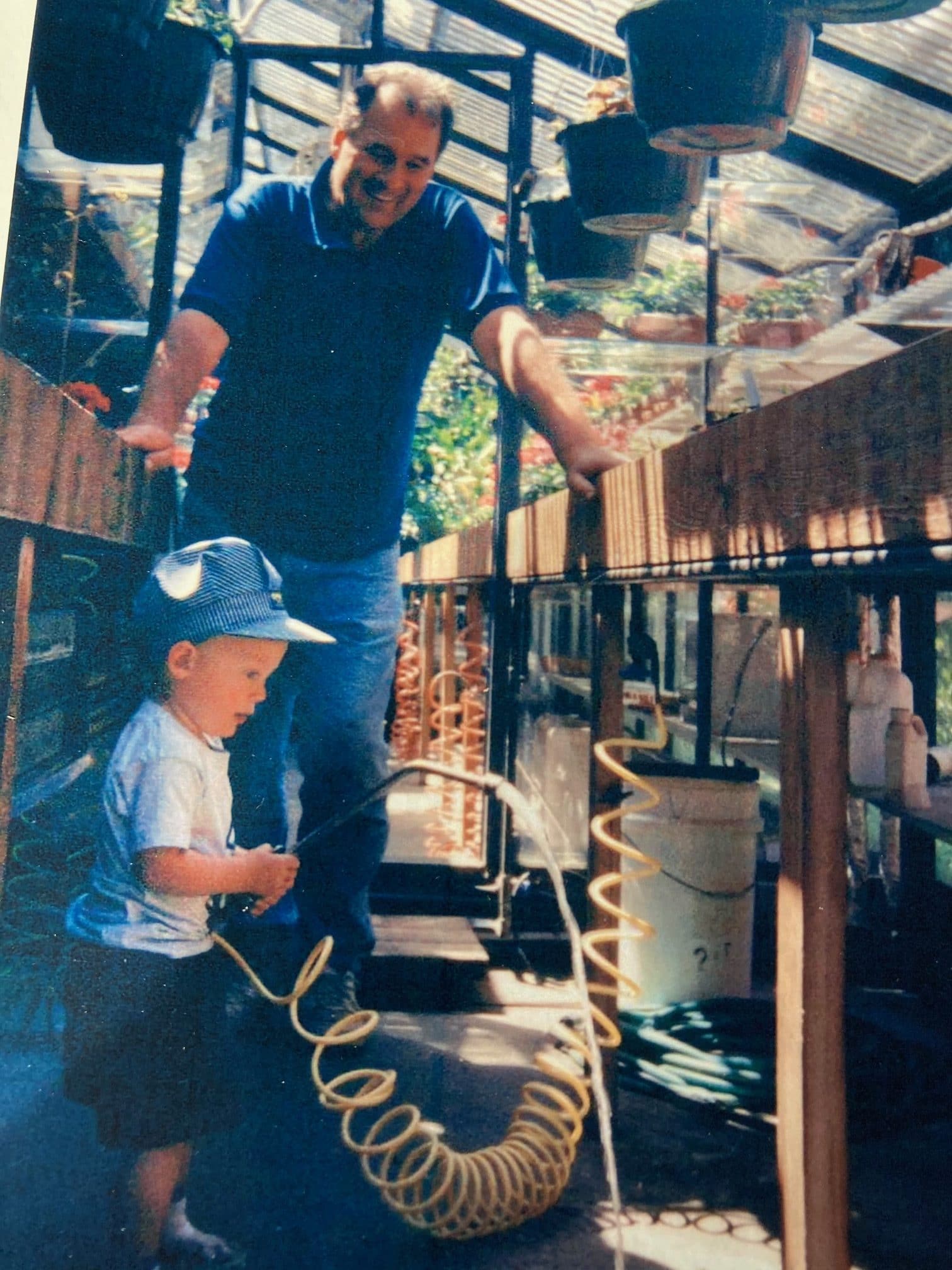 Erik in his lean-to greenhouse with young Aarron